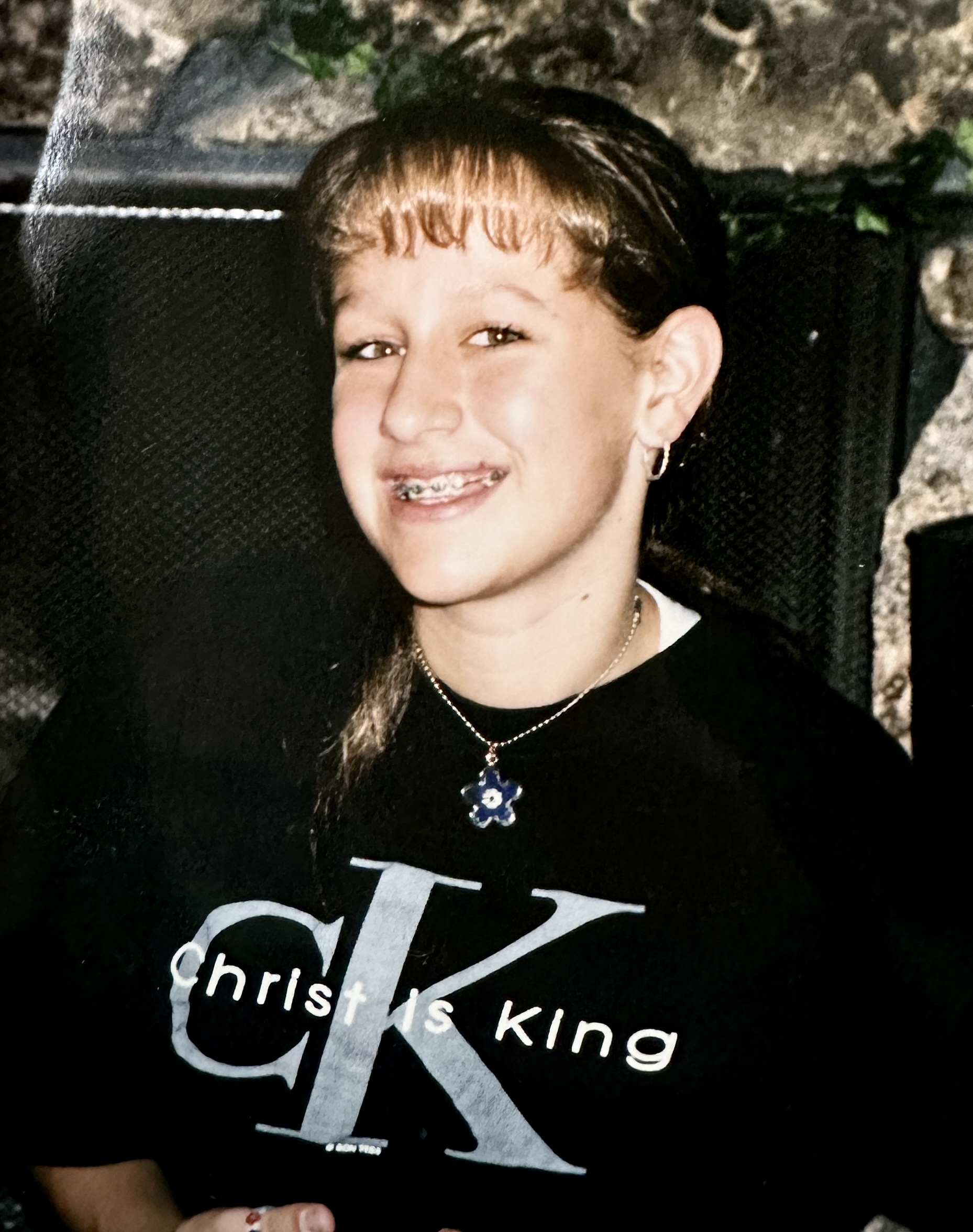 Carrie King as a child wearing a Christ is King t-shirt